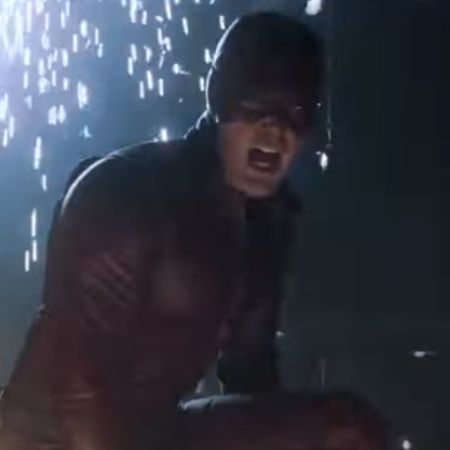 Ben Affleck is looking at something as there are sparks in the background.